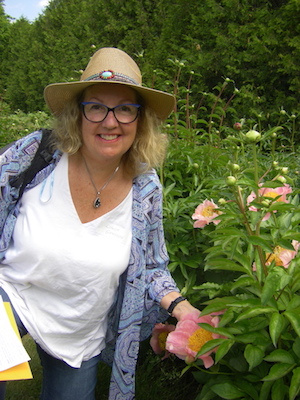 Linda from Soulscapes in Oakville glows with feminine assertiveness beside a pink peony 