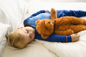 baby in crib with teddy bear